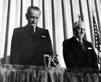 President Lyndon B. Johnson and Senator Frank Carlson bow their heads solemnly