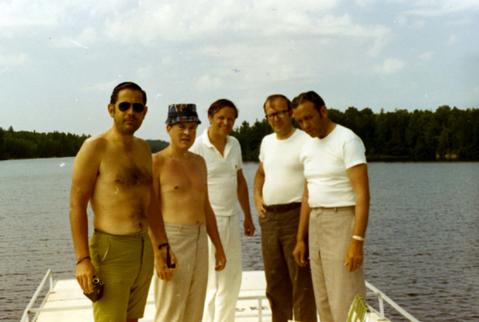 Frank Denholm (right) with four other men standing on a dock at a lake.