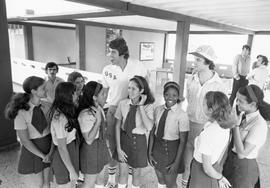 Member of South Dakota basketball delegation to Cuba in USA team shirt with Cuban girls in school uniforms