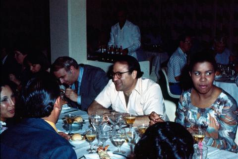 James Abourezk smiling and dining with others in Cuba